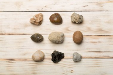 Ahşap zemin üzerinde deniz taşları seti, üst manzara.