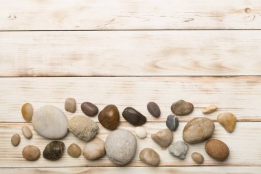 Ahşap zemin üzerinde deniz taşları seti, üst manzara.