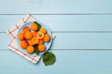 Composition with ripe apricots on wooden background, top view.