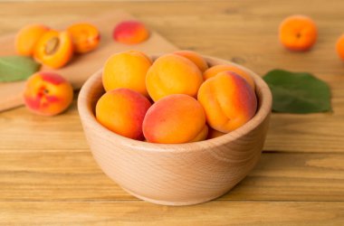 Composition with ripe apricots on wooden table.
