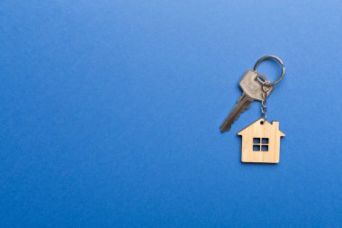 Renk arkaplanında ev şekilli anahtarlık.