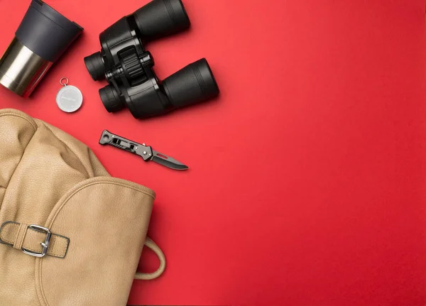 Travel accessories for mountain trip on color background, top view.
