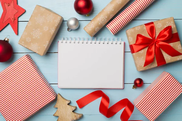 Gift boxes, paper's rools and decorations on wooden background, top view.