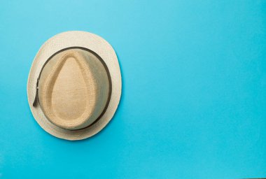 Straw hat on color background, top view.
