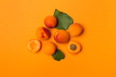 Flat lay with ripe apricots on color background, top view.