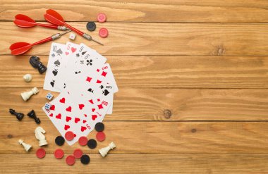 Tahta arka planda farklı masa oyunları, üst görünüm.