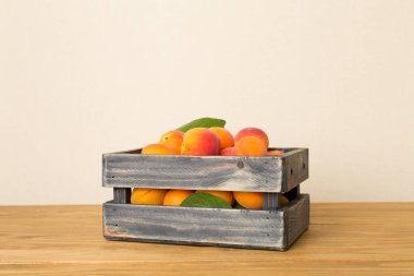 Composition with ripe apricots on wooden table.