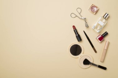 Different makeup products on color background, top view.