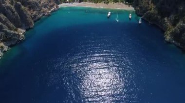 Beautiful Butterfly Valley in Fethiye Turkey - drone flying over the bay of water, heading for the mountains.