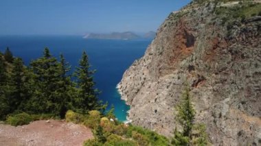 Türkiye 'nin Fethiye kentindeki Kelebek Vadisi' nin hava görüntüsü insansız hava aracı çam ağaçları, arka plandaki deniz ve dağlar ve sonunda inanılmaz Kelebek Vadisi 'nden uçuyor..