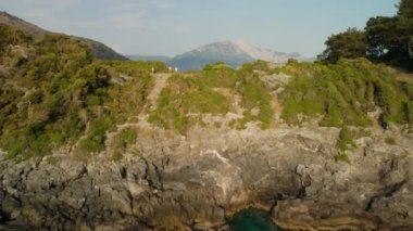 Bir grup turist Kayakoy Körfezi 'ndeki güzel deniz manzarasına hayran kaldılar. İnsansız hava aracı deniz seviyesinden başlayıp yeşil çam ağaçlarıyla kaplı kayaların üzerinden Mavi Deniz Koyu' na doğru uçuyor..