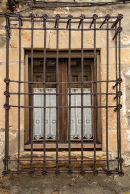 Ortaçağ 'a ait güzel dantel perdeleri olan antika işlemeli demir pencere manzarası.