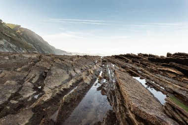 Misty sunset over flyschs at Aitzuri beach in Gipuzkoa, North of Spain
