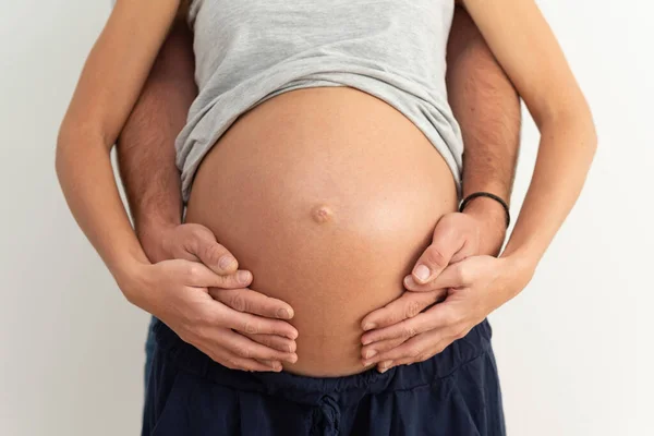 New parents expecting a baby and embracing the pregnant belly.