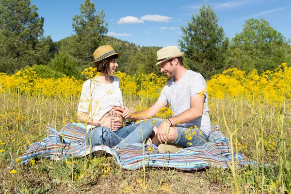 Pregnant Smiling Couple Sitting Blanket Meadow Full Tall Yellow Flowers — ストック写真