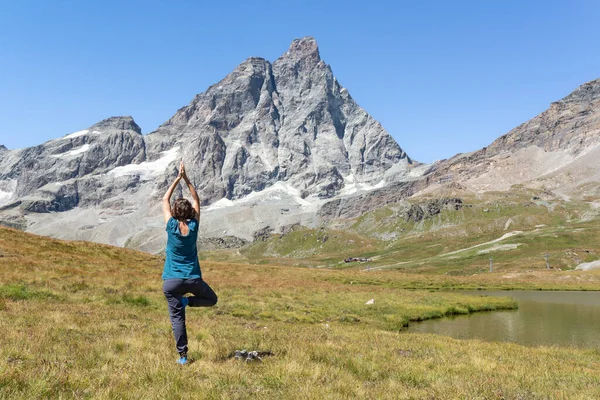 Achteraanzicht Vrouw Oefenen Yoga Een Groene Weide Bij Een Berg — Stockfoto