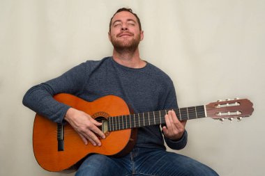 Mutlu adam İspanyol gitarını çalarken eğleniyor..