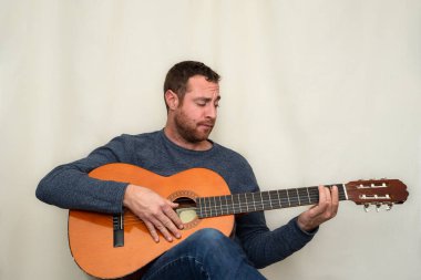 Gitar çalan sakallı yakışıklı bir adamın portresi.. 