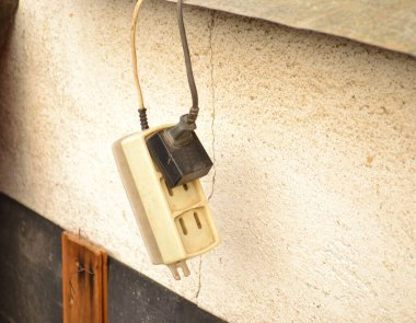 Duvarın yanında asılı eski uzatma kablosu
