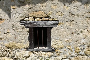 Taş duvardaki antik ahşap paslı metal pencere.