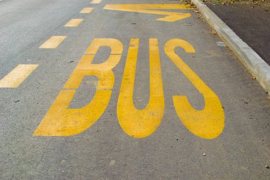 Sarı boyalı yol tabelası sürücüleri bir otobüs durağı olduğu konusunda uyarıyor.