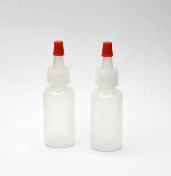 Biała Plastikowa Butelka Czerwonym Wieczkiem Szarym Tle — Zdjęcie stockowe