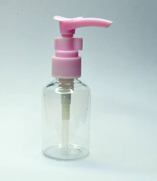 Gri arkaplanda plastik pembe sabun dağıtıcısı
