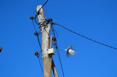 Sokak lambası ve elektrik kabloları olan eski ahşap bir havuz.