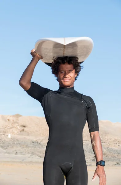 Portret Młodego Afrykańskiego Surfera Trzymającego Deskę Surfingową Uśmiechającego Się — Zdjęcie stockowe