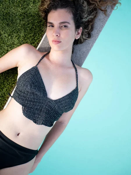 Attractive Hispanic Young Woman Lying Pool Wearing Elegant Crochet Bikini — стоковое фото