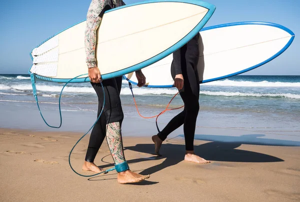 Nierozpoznane Surferki Spacerujące Brzegu Plaży Trzymające Deski Surfingowe Noszące Zimowe — Zdjęcie stockowe