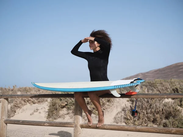 Młoda Surferka Afro Włosami Obserwująca Fale Siedzące Płocie — Zdjęcie stockowe