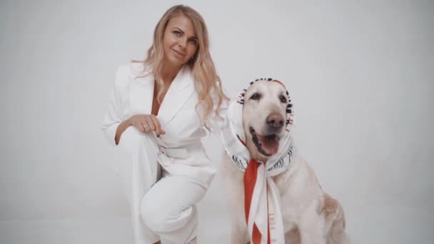 Branco Golden Retriever Filhote de cachorro com proprietário menina posando para câmera no fundo branco. Movimento lento — Vídeo de Stock