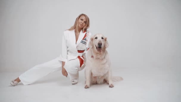 White Golden Retriever Puppy with Owner Girl 이 하얀 배경 카메라에 포즈를 취하고 있습니다. 느린 동작 — 비디오