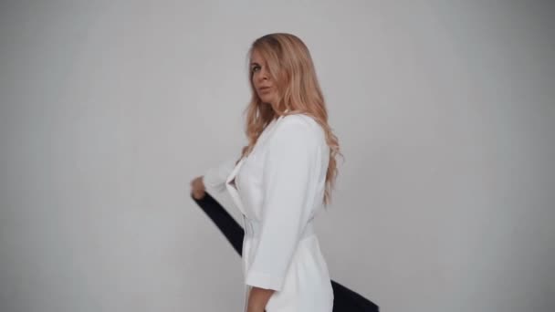 Femme sur un fond blanc agitant écharpe noire. Mouvement lent — Video