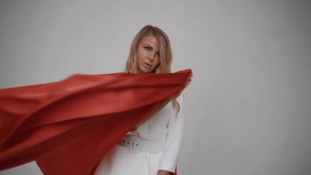 Vrouw op een witte achtergrond zwaaien rode sjaal. Langzame beweging — Stockvideo