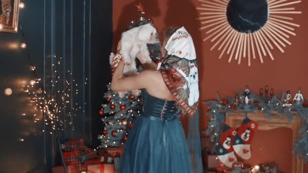 Mooi Meisje Met Een Sjaal Een Hondje Haar Armen Kerstboom — Stockvideo