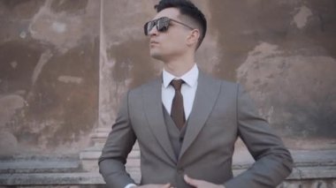 Modern binanın yakınında takım elbiseli ciddi bir işadamı yürüyor. Sokakta kendine güvenen gözlüklü bir iş adamı. Yavaş çekim