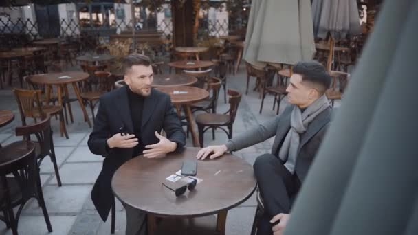Des hommes sérieux en costume assis dans un café. Mouvement lent — Video