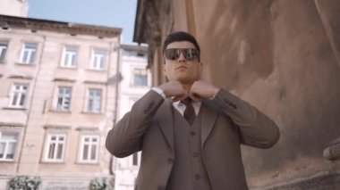 Modern binanın yakınında takım elbiseli ciddi bir işadamı yürüyor. Sokakta kendine güvenen gözlüklü bir iş adamı. Yavaş çekim