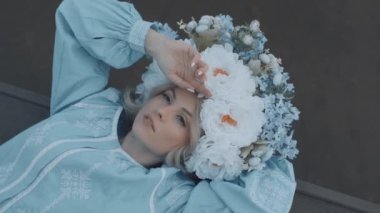 Kafasında çelenk olan Ukrayna vatandaşı bir kadın. Nakış. Nakış. Sahilde yatan kadın. Yavaş çekim