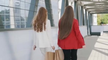 Happy young girls friends with shoping bags, talking and laughing. slow mo steadicam shot