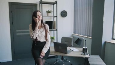 İş kadını takım elbiseli, ofiste telefonla konuşuyor. İş içeriği