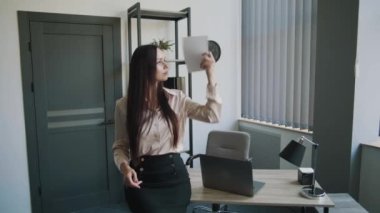 Ofiste elinde bir defter sallayan güzel genç bir kadın. Sıcak hava. İş içeriği