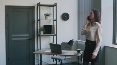 İş kadını takım elbiseli, ofiste telefonla konuşuyor. İş içeriği