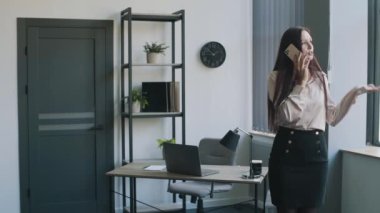 İş kadını takım elbiseli, ofiste telefonla konuşuyor. İş içeriği