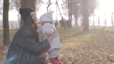 Mutlu aile, anne ve kızı sonbaharda parkta birlikte. Yavaş çekim