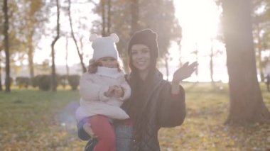 Mutlu aile, anne ve kızı sonbaharda parkta birlikte. Yavaş çekim