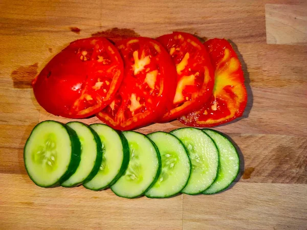 Concombre et tomates en lamelles sur fond bois