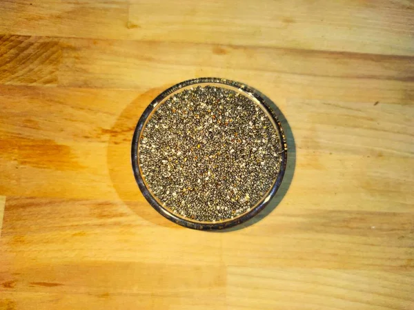 Graines de chia sur fond bois